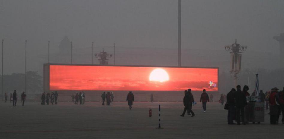 Pantallas gigantes muestran imágenes del amanecer en la Plaza de Tiananmen bajo un cielo gris.jpeg